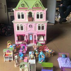 there is a doll house with furniture and toys in front of it on the floor