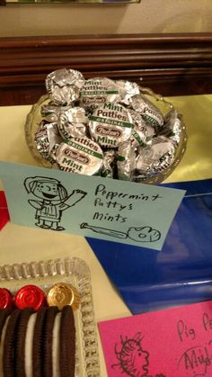 there is a plate full of chocolates and candy on the table with note cards