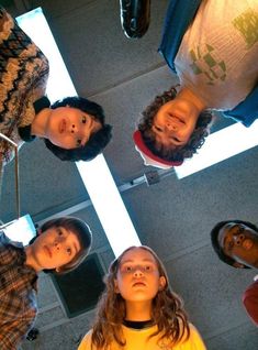 four people standing in a circle looking up at the camera