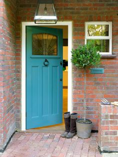 the front door is painted blue and has potted plants