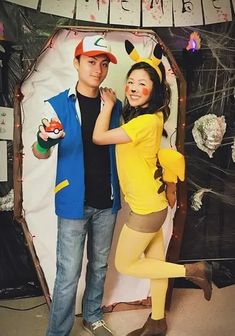 a man and woman dressed up as pokemons posing for a photo together in front of a backdrop