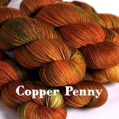 several skeins of orange and yellow yarn with the words copper penny on it