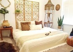 a bedroom with a white bed, brown and tan pillows and rugs on the floor