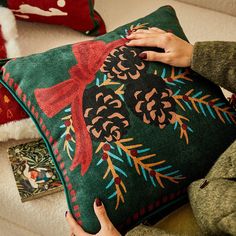 a woman is holding a decorative pillow on the couch