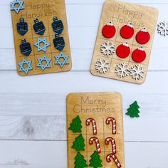 three wooden christmas themed magnets sitting on top of a table