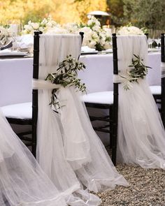 the chairs are covered with white tulle and tied with ribbons for an elegant look