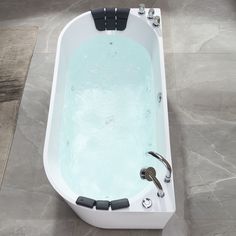 an aerial view of a white bathtub with water running down the side and two faucets in it