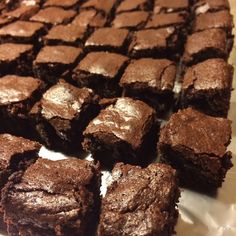 several pieces of brownie sitting on top of white paper