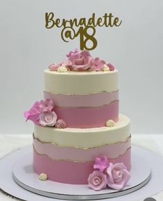 a three tiered cake with pink flowers on top