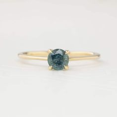 Approximately 0.55ct. 5mm Montana sapphire, eye clean Band width: 1.1mm to 1.4mm tapered band High profile four prongs flower setting Made of 100% recycled solid 14k gold and ethically sourced gemstones Colors may vary slightly as they are genuine gemstones Photos of the ring on the model are using a different ring, please refer to the main photo and video Packaged in a white craft paper ring box Custom Order This ring is offered in other sizes, metal, and the center stone can be upgraded/downgr Timeless 14k Gold Sapphire Ring With Tension Setting, Minimalist Yellow Gold Sapphire Ring With Prong Setting, Yellow Gold Sapphire Ring With Tension Setting, Yellow Gold Sapphire Solitaire Ring, Green Montana, Flower Setting, Ivory Ring, Montana Sapphire Ring, Sapphire Solitaire Ring