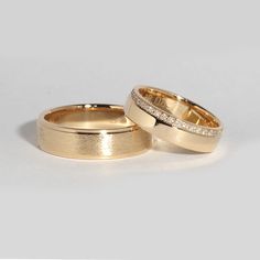 two gold wedding rings with diamonds on them