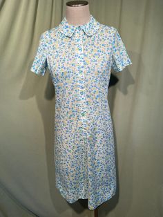 This is a cute vintage dress from the 60's. No labels or tags. It is home sewn.  There isn't a size tag. The bust measures 36", waist 32", see measurements below.  Made of white, blue, green & yellow cotton blend fabric in a small floral print.  The dress is not lined.  It has short sleeves. The collar is small. Buttons down the front to below the waist. The shape is very straight.  The dress is in very good condition, no wear or tear.  No soil or stains.  Measurements were taken with the garment lying flat. If you have never worn vintage before, please measure yourself!! Vintage sizes run smaller than today's sizes, you need to know your measurements! If you have any questions about measuring, please ask before purchasing.  Bust measured 2" below underarm from side seam to side seam: 18" Green Floral Print Dress, 60s Home, 60s Fashion Dresses, Short Sleeve Shirt Dress, Button Maxi Dress, Chambray Shirt Dress, Shirtwaist Dress, Short Sleeve Dress Shirt, Lace Top Long Sleeve