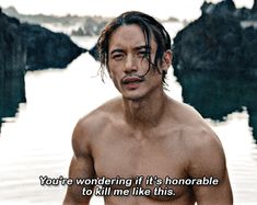 a shirtless man standing in front of water with a quote written on the chest