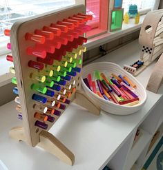 a child's desk with toys on it and a basket full of crayons