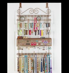 a wall mounted jewelry rack with several pairs of earrings