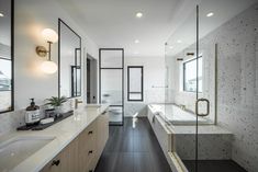 a large bathroom with white walls and wood flooring, along with a walk in shower