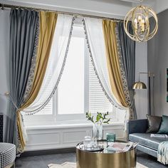 a living room filled with furniture and a large window covered in gold curtained drapes