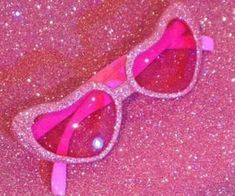 a pair of pink sunglasses with glitter on them