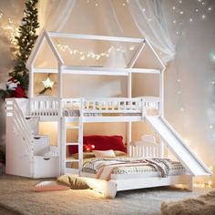 a white dollhouse bed with stairs to the top and bottom bunk, next to a christmas tree