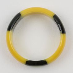 This is part of Chairish’s Costume Jewelry assortment.  This is an outstanding Belle Kogan Bakelite elongated inlay dot bracelet bangle. The dots are set with true licorice black surrounds, in a light banana yellow color, and appear three times around the bangle. The bracelet has a domed shape and is set in the same banana-yellow color. This is one of the rarer of Belle Kogan's designs. Measurements: Inside across 2.50 in diameter (6.3 cm) - outside across 3.07 in diameter (7.8 cm) - width is 0. Modern Black Round Bangle, Modern Black Bangle, Bakelite Bracelets, Banana Yellow, Bracelet Bangle, Licorice, Yellow Color, Costume Jewelry, Bangle Bracelets