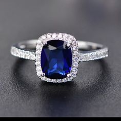 a blue sapphire and diamond ring on a black surface