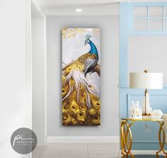 a peacock painting hanging on the wall next to a table with a lamp in it