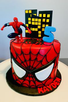 a spiderman themed birthday cake with the number five on it's face and hands