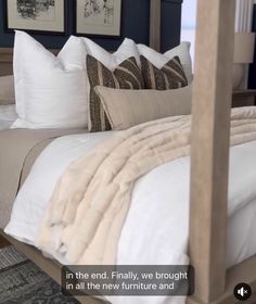 a bed with pillows and blankets on top of it in a room that has blue walls