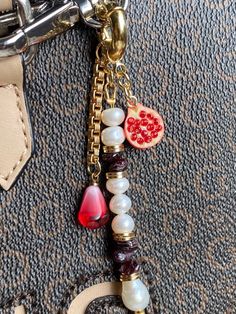 This piece of jewelry can be used as a bag charm, a keychain, or a decoration for any other item.  * Gold: Brass/copper/St.steel + 18K Gold plated * Platinum: Brass/copper/St.steel + Rhodium plated * Freshwater &  Baroque pearls; Natural Garnet stones; Zircon pendant * No risk of allergy (nickel-free, lead-free, cadmium-free) * Full length: 90 mm * The shape and color of the stones and pearls may vary * Delivered with a cleaning cloth and a ready-to-gift jewelry storage pouch * FREE USAVEL GIFT Cheap Keychain Bag Charm As Gift, Luxury Logo Bag Charm For Gift, Luxury Logo Bag Charm As Gift, Elegant Bag Charm With Charms As Gift, Rectangular Keys Bag Charm For Gift, Welsh Christmas, Charm Keychains, Bags Business, Purse Keychain