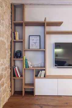 an entertainment center with bookshelves and a flat screen tv mounted on the wall