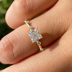 a woman's hand with a diamond ring on it