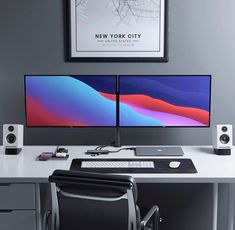 two computer monitors sitting on top of a white desk next to a keyboard and mouse