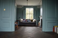 a living room with blue walls and wood floors