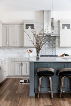 two stools sit at the center of a kitchen island