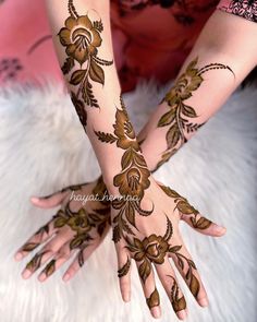 two hands with henna tattoos on them