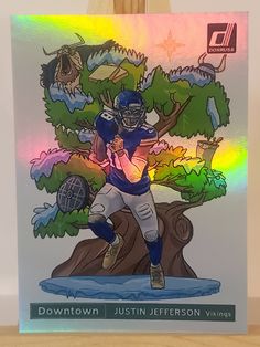 a drawing of a football player holding a ball in front of a tree with the words downtown