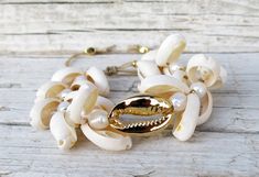 This beautiful cowrie set bracelet is made with natural white cowrie shells, natural gold cowrie shells, big 24k gold plated cowrie shell, freshwater pearls, 24k gold plated beads and beige silk cord. Bead size: shell 1,5 - 2 cm / 0,6 - 0,8 inch.; gold shell 2,5 cm/ 1 inch.; gold plated beads 0,3 cm /0,1 inch. Your bracelet comes gift wrapped and shipped via priority registered air mail with tracking info available. Feel free to ask me any questions! Thanks for visiting and happy shopping :) Cowrie Shell Beaded Bracelets As Gift, Adjustable Gold Shell-shaped Bracelet, White Cowrie Shell Bracelet, Gold Shell Beaded Bracelets As Gift, Bohemian Gold Beaded Bracelets With Shell, Bohemian Gold Beaded Shell Bracelets, White Cowrie Shell Bracelets For Beach, Gold Cowrie Shell As Gift, Gold Shell-shaped Bracelet For Vacation