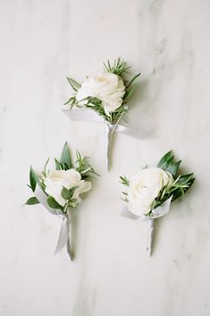 three bouquets of white flowers on a marble surface