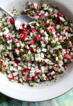 a white bowl filled with chopped radishes and herbs