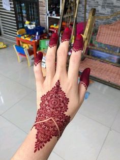 a woman's hand with hendix on it and red nail polishes