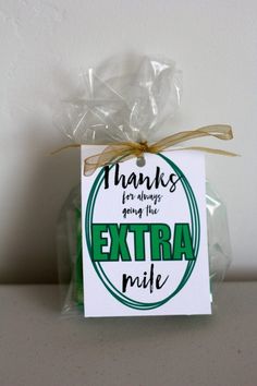 an extra mile sign is wrapped in clear cellophane and tied with a brown ribbon