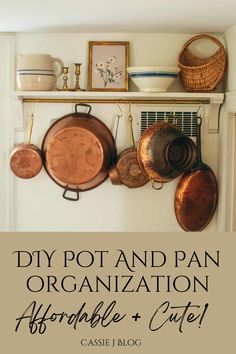 pots and pans are hanging on the wall above a shelf with other kitchen utensils