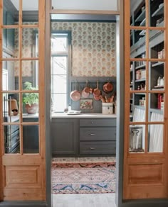 an open kitchen door with pots and pans on the shelves in front of it