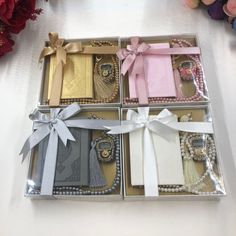 a box filled with lots of different types of jewelry next to red flowers and other items