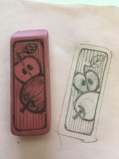 a drawing of an apple in a box next to a rubber stamp