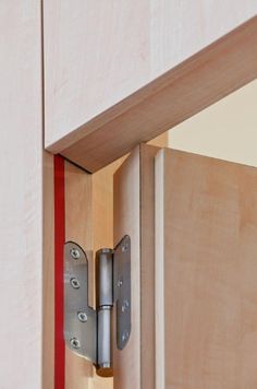 an open cabinet door with a metal hinge and red stripe on the bottom half