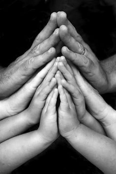 many hands are stacked together to form a pyramid on top of each other in black and white