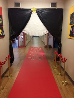 a red carpeted hallway with black drapes and gold star decorations