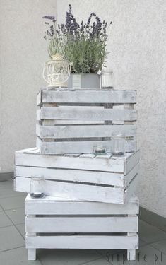 a stack of wooden crates with plants on top