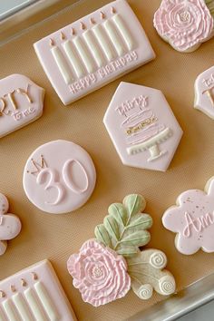 decorated cookies in the shape of flowers and candles are arranged on a cookie sheet with icing